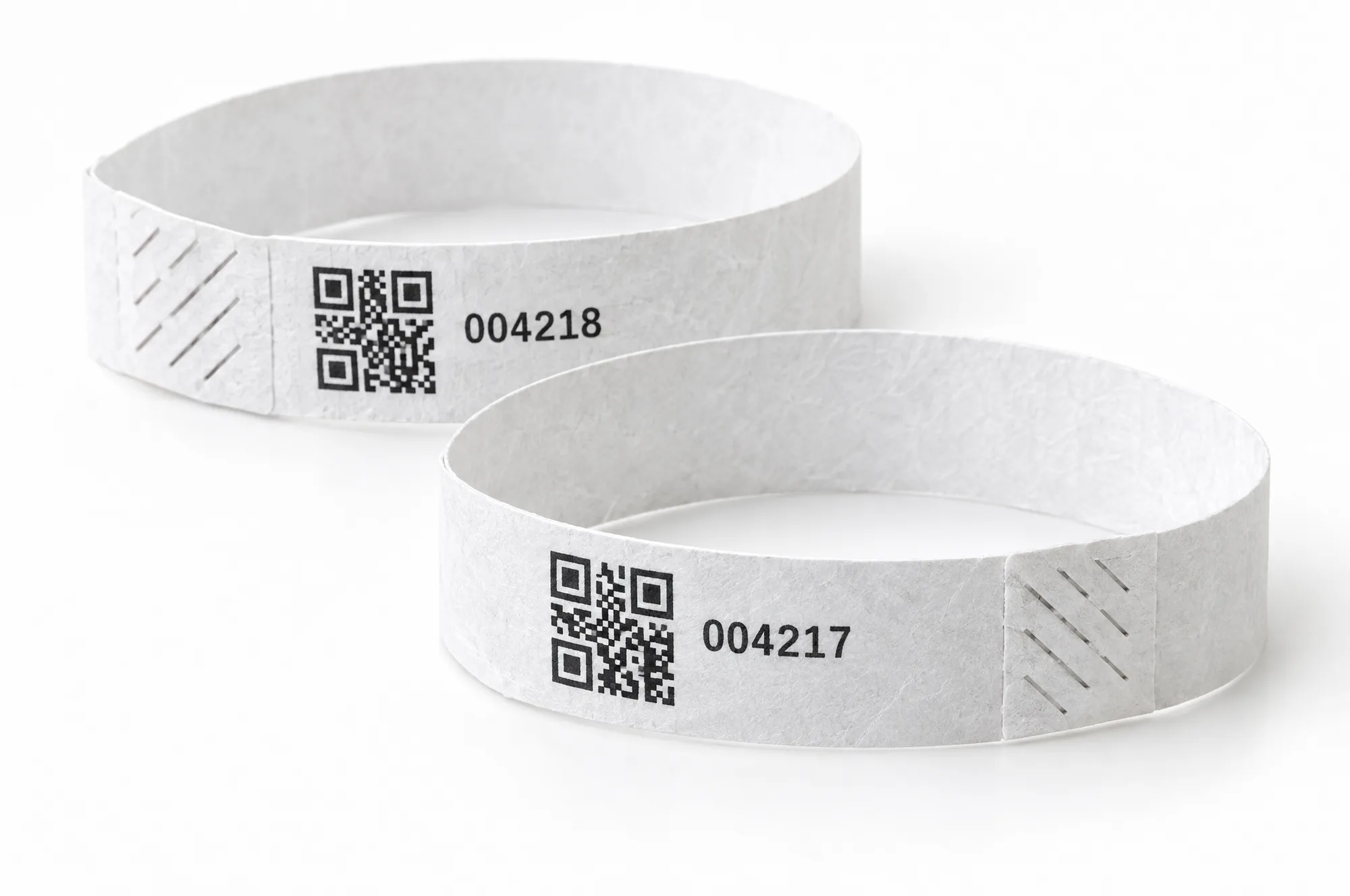 Two white wristbands printed with QR codes and the numbers 004217 and 004218