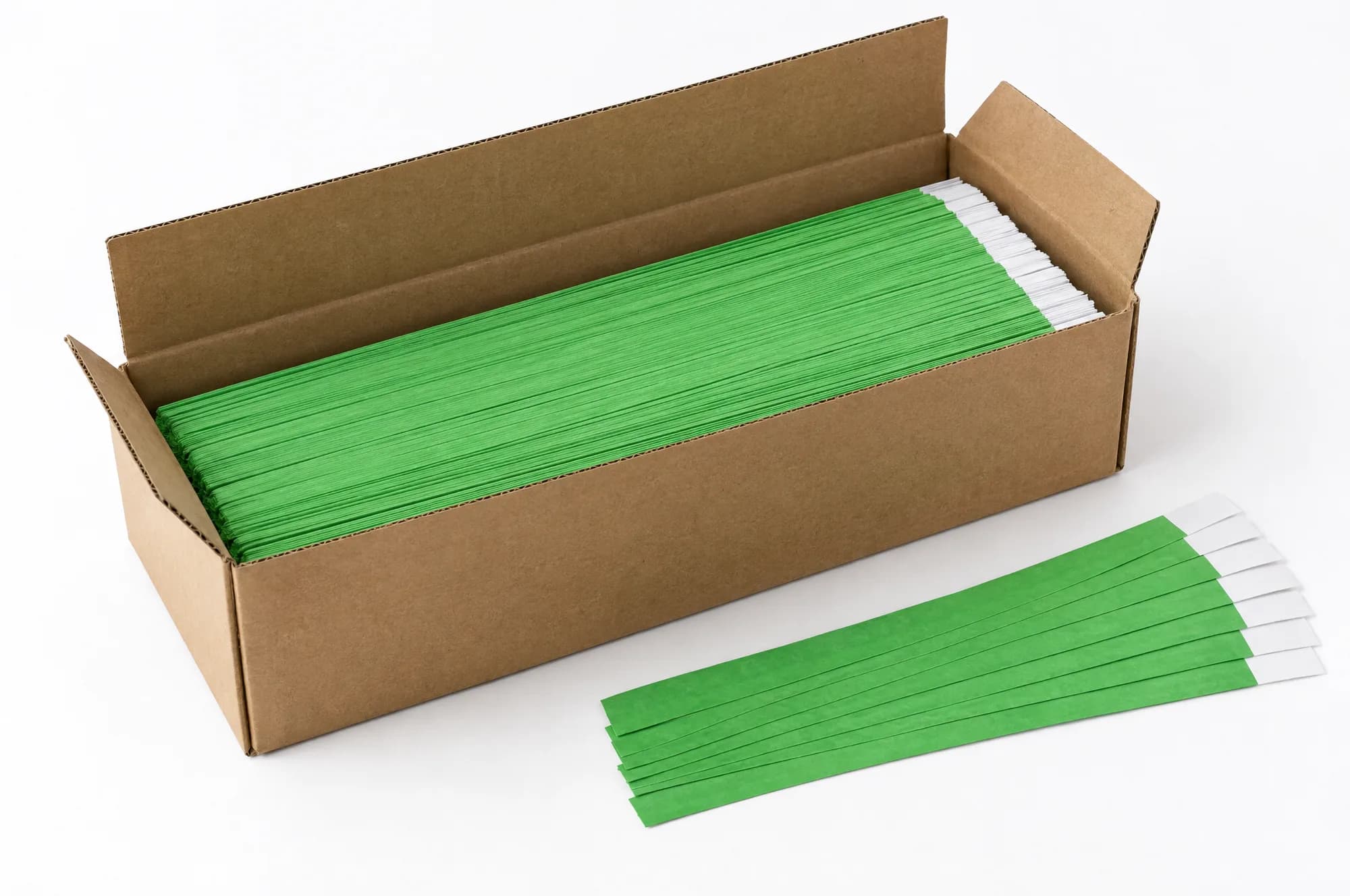 An open carton of flat green paper wristbands with a few loose bands beside it